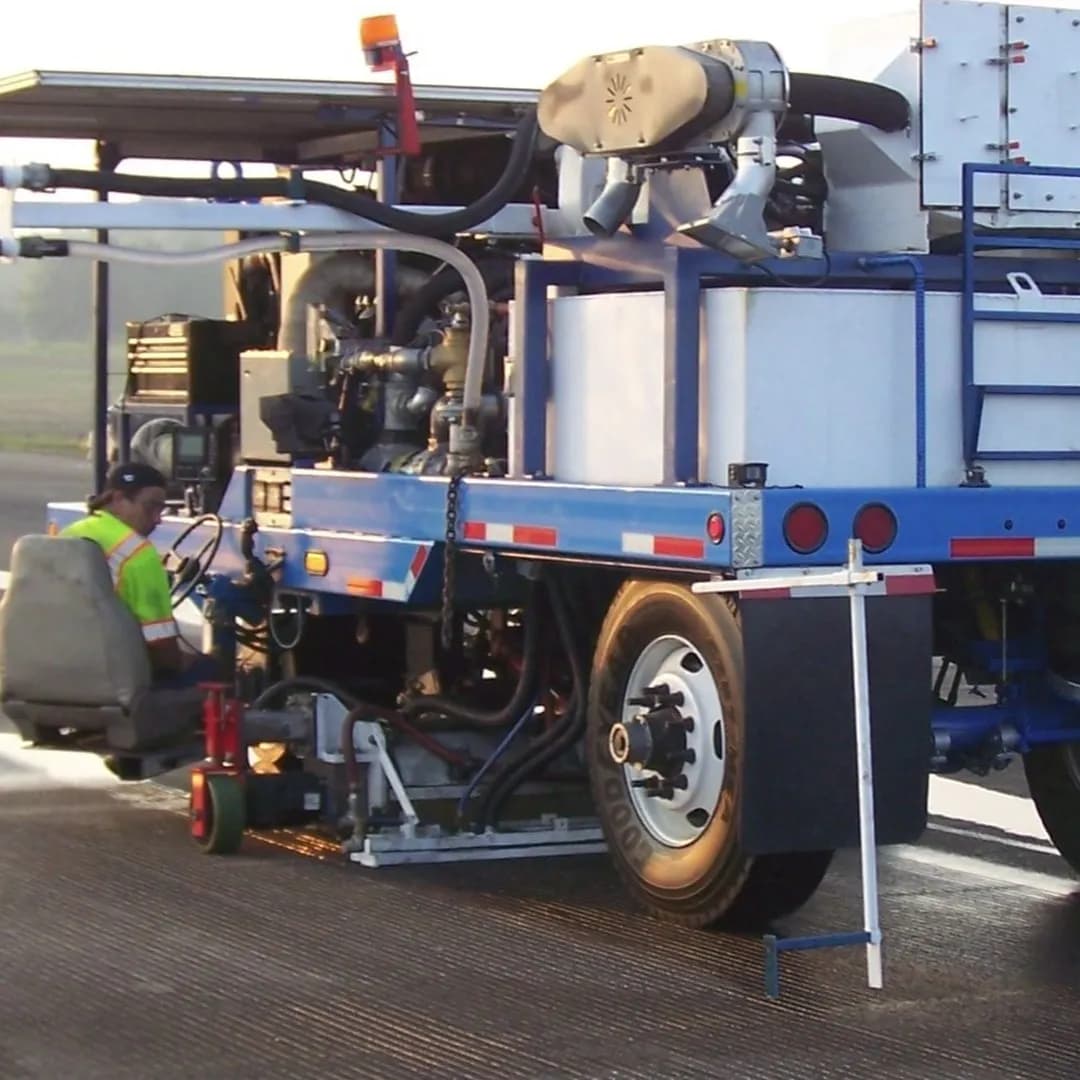 A heavy-duty industrial road maintenance vehicle equipped with a Sonic Air Systems blower and specialized nozzles.