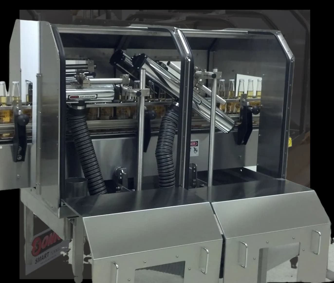 Sonic Air Systems air knife set mounted over a high-speed bottling line within a stainless steel Smart Tunnel enclosure.